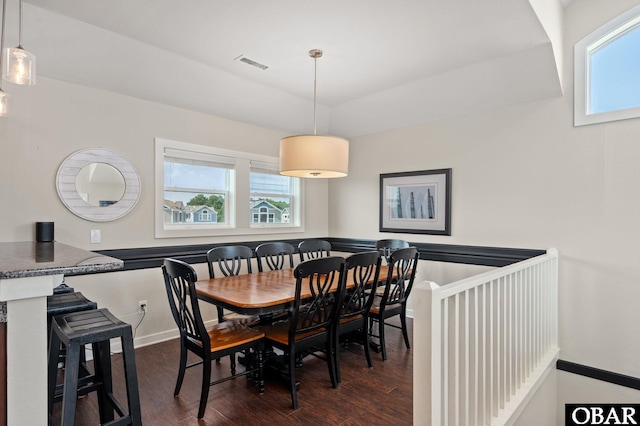 dining area featuring dark wood-style floors, visible vents, and baseboards