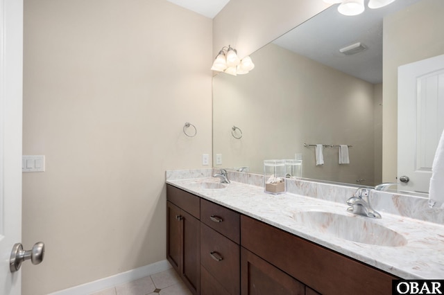 bathroom featuring double vanity, tile patterned floors, a sink, and baseboards