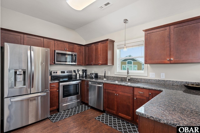 kitchen with dark wood-style floors, pendant lighting, visible vents, appliances with stainless steel finishes, and a sink