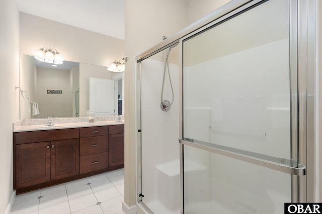 full bathroom featuring double vanity, a stall shower, and a sink