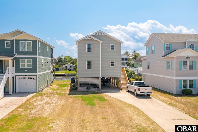 view of front of home with driveway, stairs, an attached garage, and a residential view