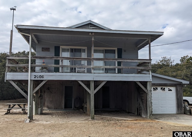 view of front of house featuring dirt driveway, a carport, and a garage