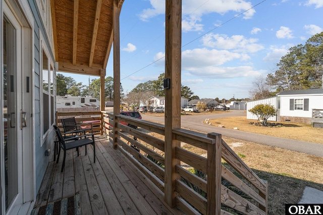 wooden terrace featuring a porch and a residential view