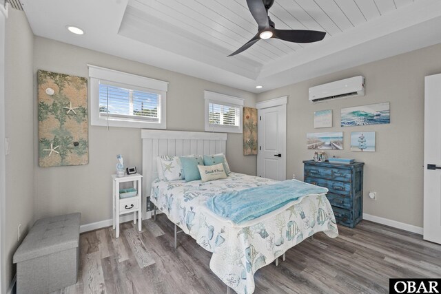 bedroom featuring a raised ceiling, wooden ceiling, baseboards, and a wall mounted AC