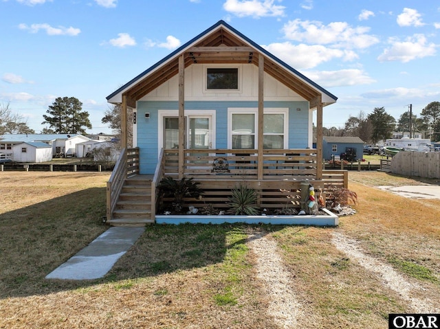 bungalow-style home with a front lawn and fence