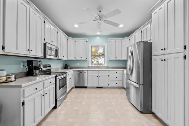 kitchen featuring a sink, white cabinetry, recessed lighting, stainless steel appliances, and light countertops