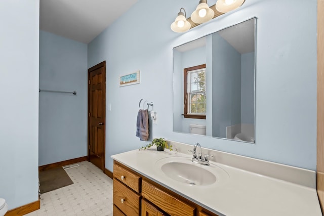 bathroom featuring toilet, vanity, and baseboards