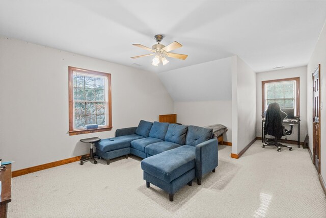 living room featuring baseboards, light colored carpet, ceiling fan, and vaulted ceiling