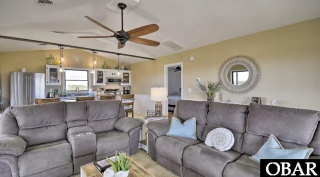 living area with ceiling fan, visible vents, and vaulted ceiling