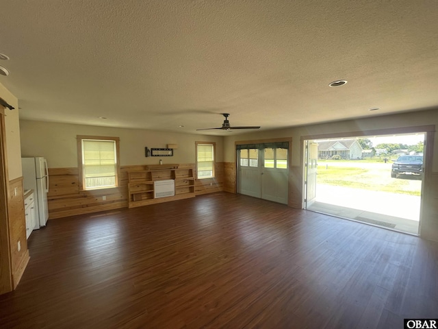 102 Daybreak Ct Lot # 53, Grandy, NC 27939 - unfurnished living room with dark wood-style floors, a textured ceiling, ceiling fan, wainscoting, and plenty of natural light