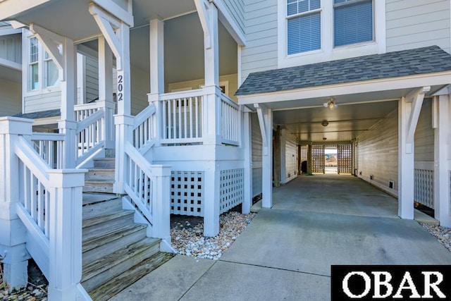 entrance to property featuring a shingled roof and driveway