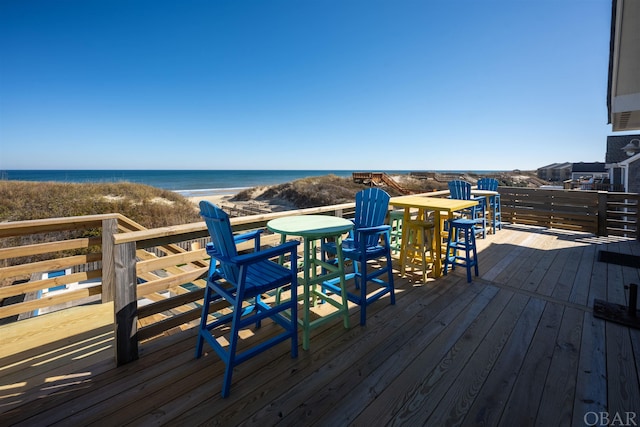 wooden deck with a water view and a view of the beach