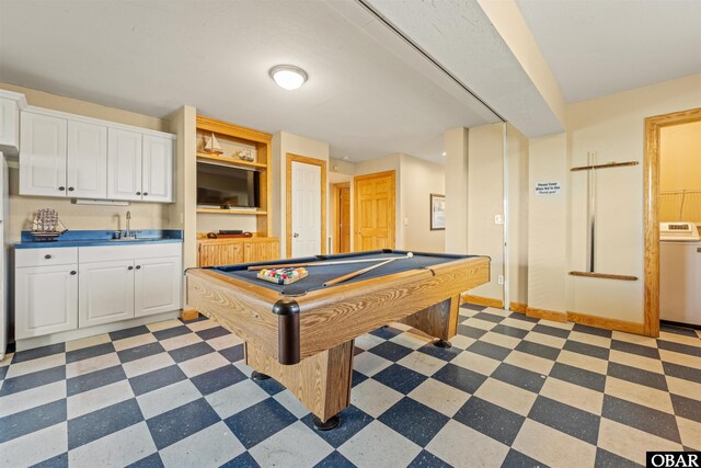 game room featuring dark floors, washer / clothes dryer, pool table, a sink, and baseboards