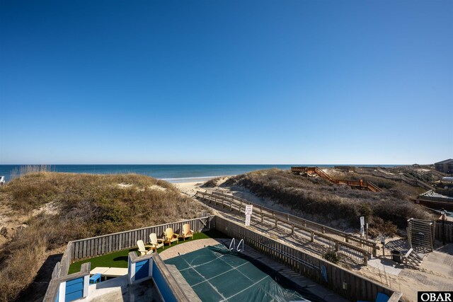 view of water feature featuring fence and a view of the beach