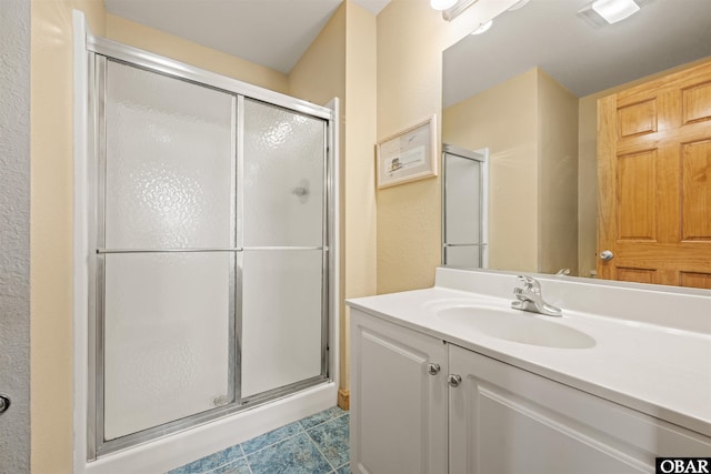 bathroom with a shower stall and vanity