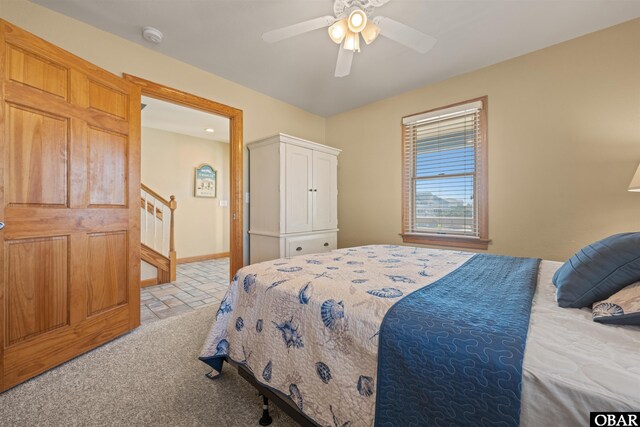 bedroom with light carpet, baseboards, and a ceiling fan