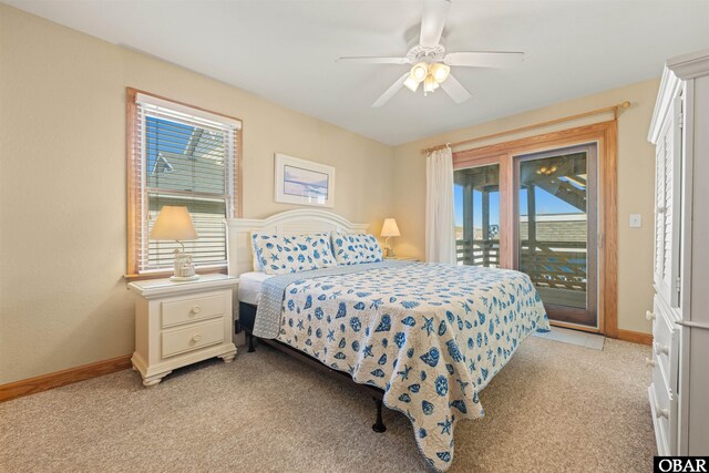 bedroom with light colored carpet, access to outside, multiple windows, and baseboards