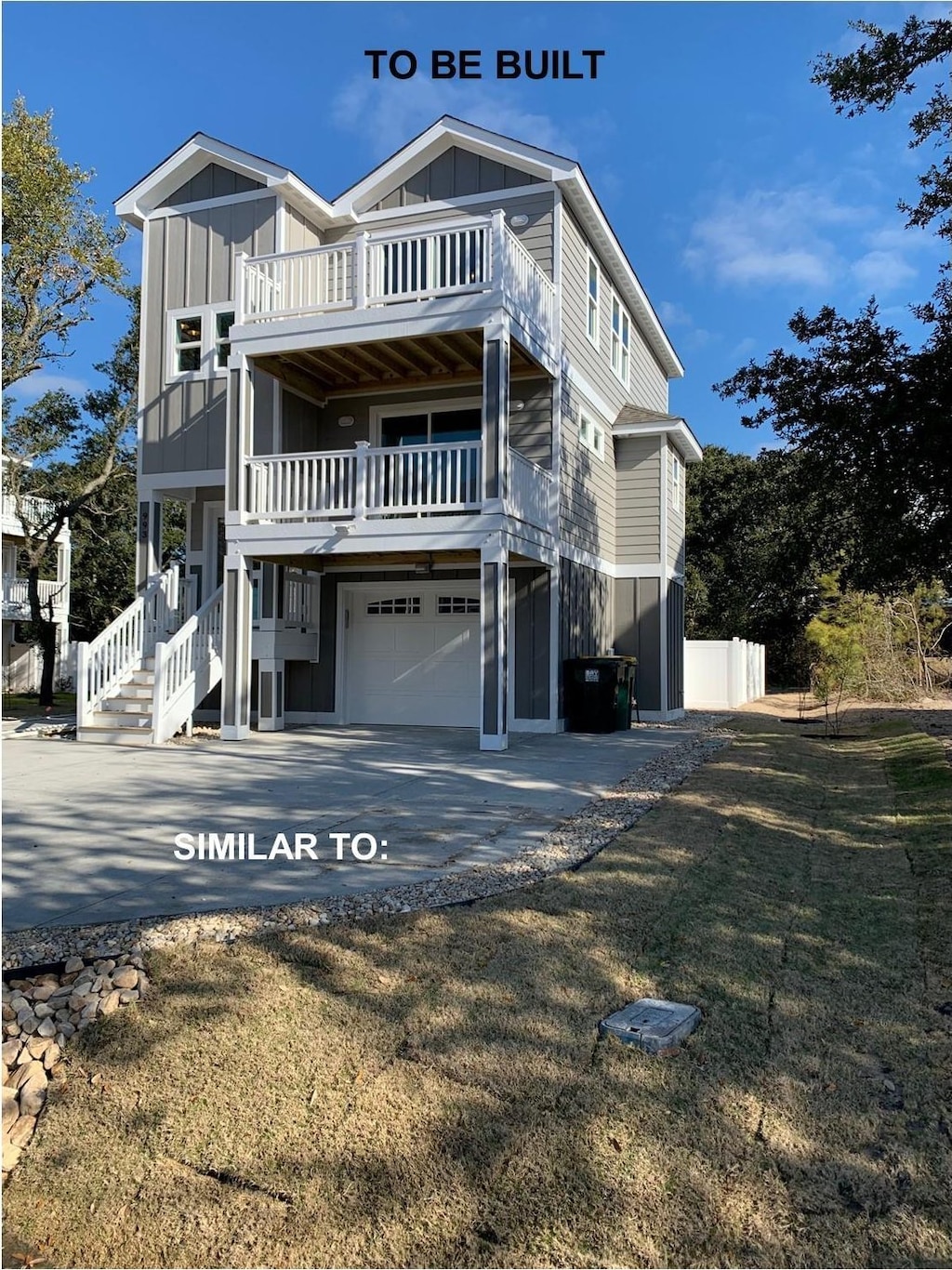 rear view of house with board and batten siding, driveway, a balcony, and an attached garage