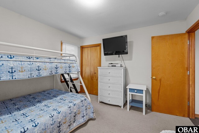 bedroom featuring light carpet and a closet