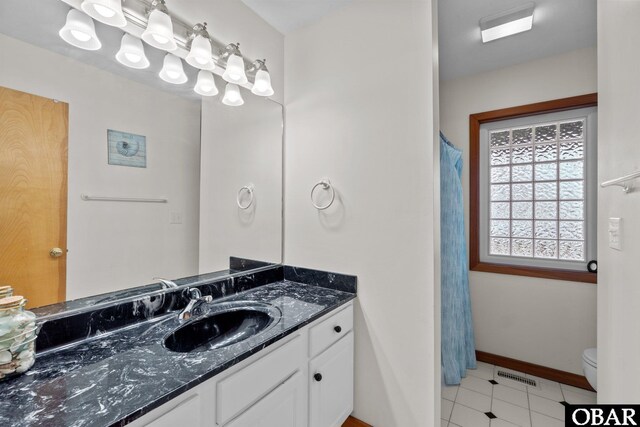 bathroom featuring toilet, baseboards, visible vents, and vanity