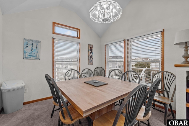 dining room with lofted ceiling, an inviting chandelier, baseboards, and carpet floors