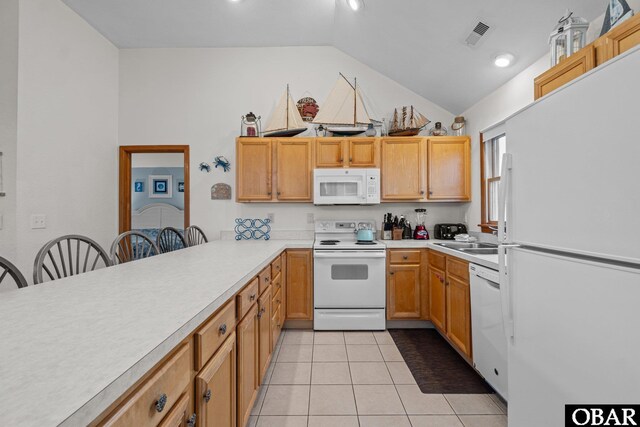 kitchen featuring a breakfast bar, light tile patterned floors, light countertops, a sink, and white appliances