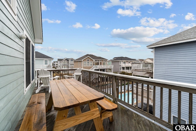 wooden terrace with a swimming pool, a residential view, and outdoor dining area