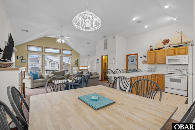 dining room with ceiling fan with notable chandelier, high vaulted ceiling, light tile patterned flooring, and visible vents