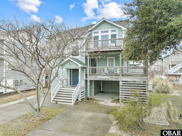 view of front of house featuring covered porch, driveway, and stairway