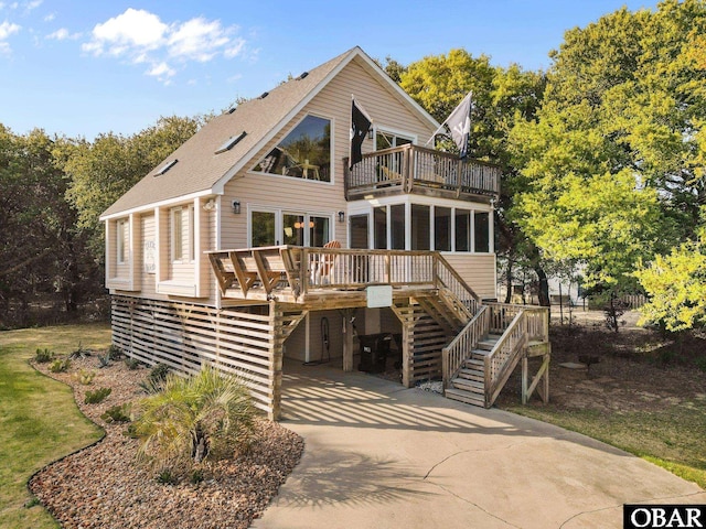 100 Tides Dr Lot 1, Duck, NC 27949 - back of house with a balcony, stairs, a sunroom, concrete driveway, and a wooden deck