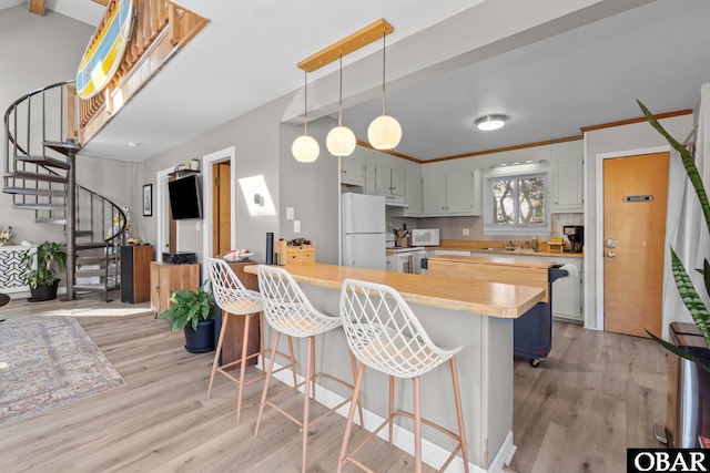 100 Tides Dr Lot 1, Duck, NC 27949 - kitchen with white appliances, a sink, a peninsula, and light wood finished floors