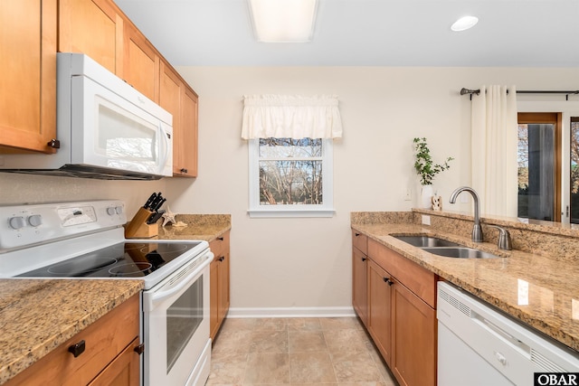 kitchen with white appliances, baseboards, a wealth of natural light, and a sink