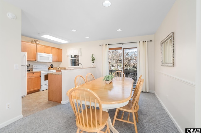 dining space with recessed lighting, baseboards, and light colored carpet