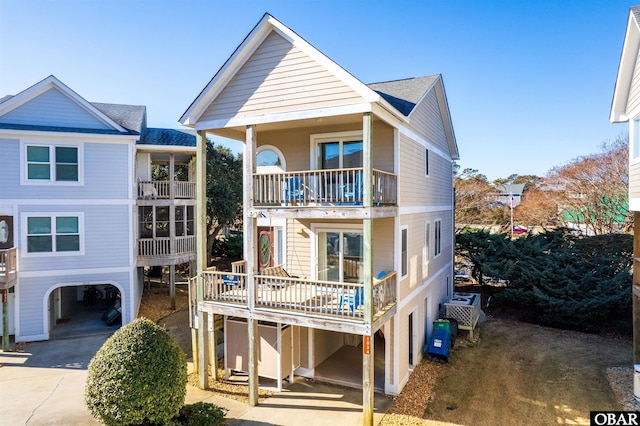 view of front of house featuring driveway, a carport, and a balcony