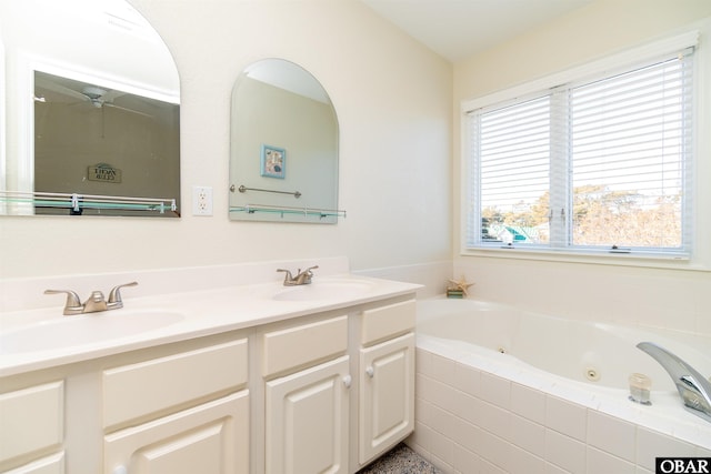 full bathroom featuring a whirlpool tub, double vanity, a sink, and a ceiling fan