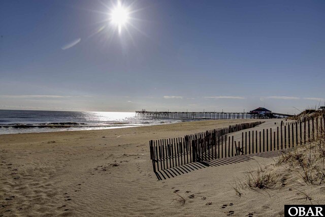 view of water feature with a view of the beach and fence