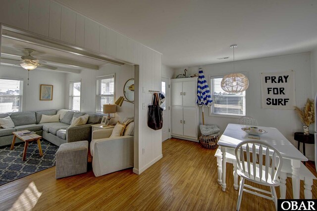 living room with ceiling fan, light wood-type flooring, and a wealth of natural light