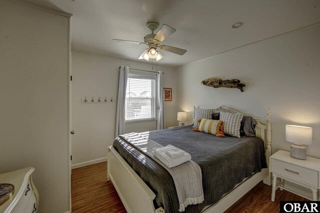 bedroom with ceiling fan, baseboards, and dark wood-style flooring