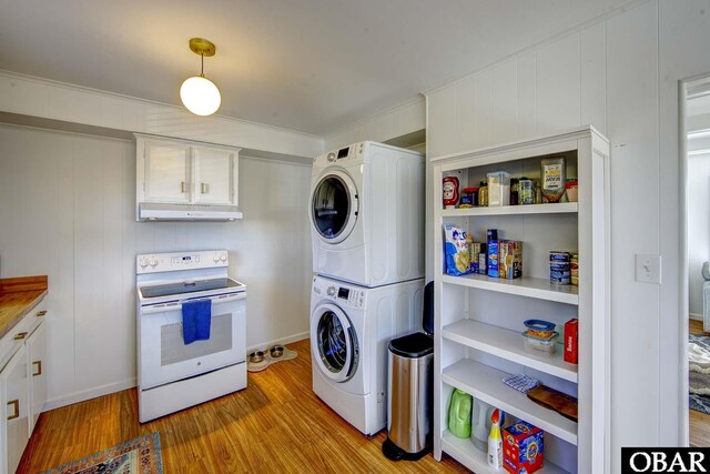 laundry room featuring stacked washing maching and dryer, laundry area, and light wood-style floors
