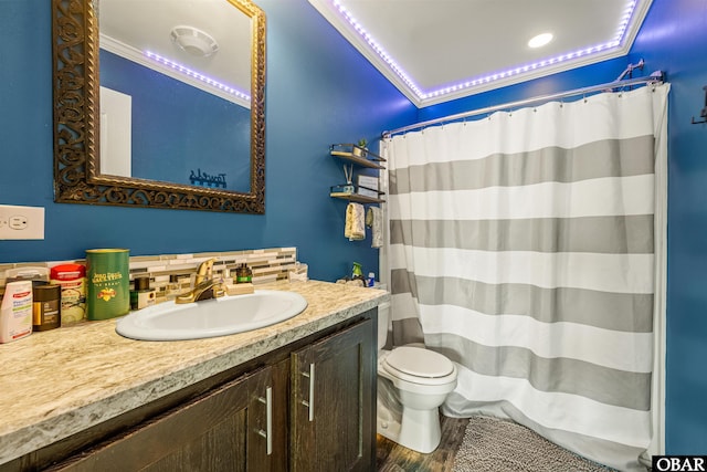 bathroom with ornamental molding, wood finished floors, backsplash, and toilet