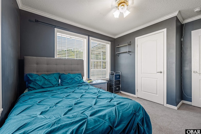 carpeted bedroom with a textured ceiling, ornamental molding, and baseboards