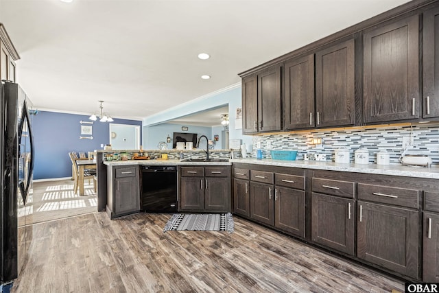 kitchen featuring a sink, black appliances, light countertops, and dark brown cabinetry