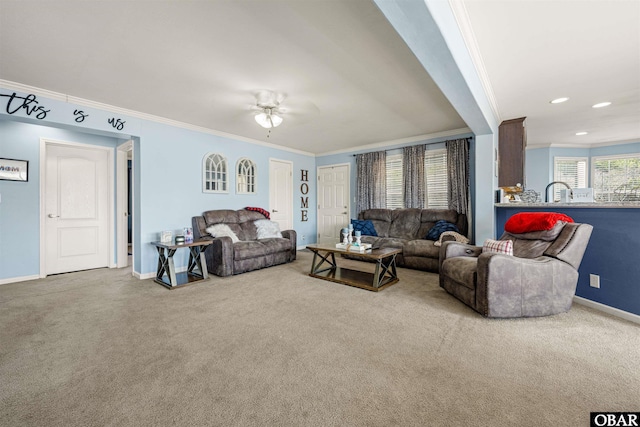 carpeted living area featuring ceiling fan, baseboards, crown molding, and recessed lighting