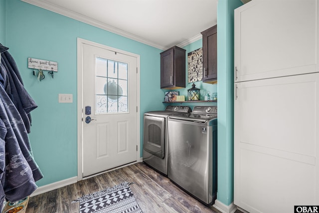 laundry area featuring cabinet space, ornamental molding, dark wood-type flooring, independent washer and dryer, and baseboards