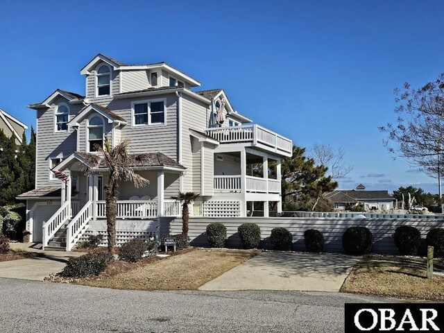 view of front of property with a porch, driveway, and a balcony