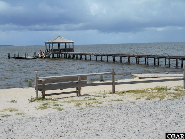 view of dock featuring a water view and a view of the beach