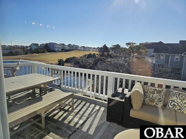 view of wooden balcony with a residential view, outdoor dining area, and a wooden deck