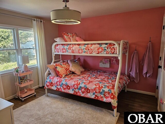 bedroom featuring dark wood-style flooring, a textured ceiling, and baseboards