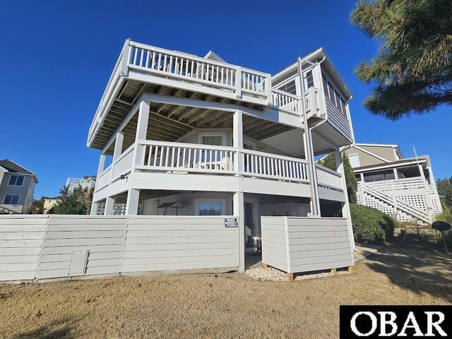 view of front of house with fence and a balcony