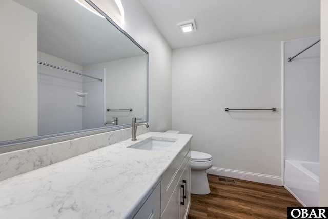 bathroom featuring baseboards, visible vents, toilet, wood finished floors, and vanity